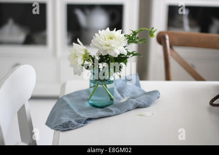 Vase of flowers and napkin on dining room table Stock Photo