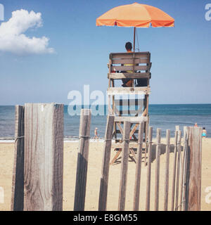 Lifeguard sitting on beach Stock Photo
