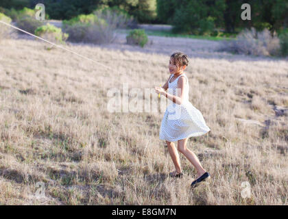 Girl flying a kite in the park Stock Photo