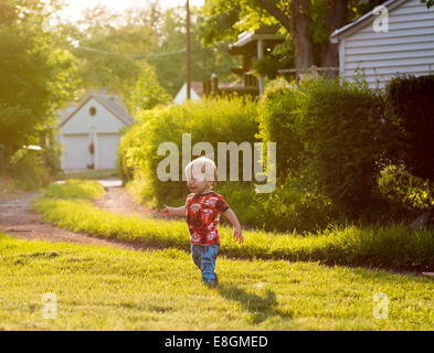 Boy playing in backyard Stock Photo