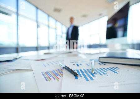 Papers with financial data on office table Stock Photo