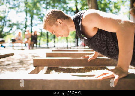 Side view of man doing push-ups at outdoor gym Stock Photo