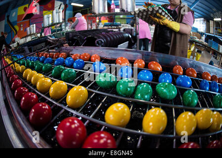 Brightly coloured Easter eggs on a conveyor belt, Beham egg dyeing company, Thannhausen, Bayern, Germany Stock Photo