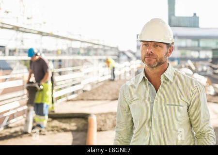 Architect looking away while standing at construction site Stock Photo