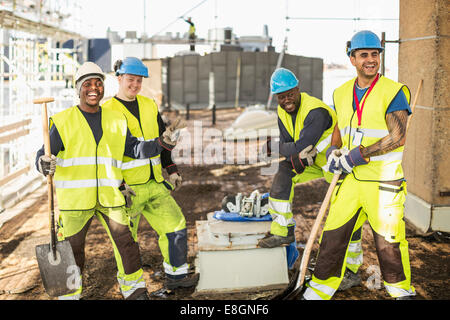 Happy construction workers at construction site Stock Photo