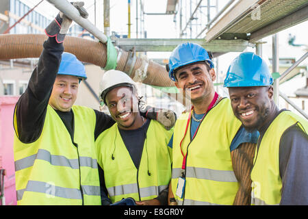 Portrait of happy construction workers standing together at site Stock Photo