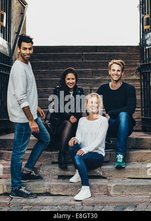 Portrait of happy multi ethnic friends on steps Stock Photo