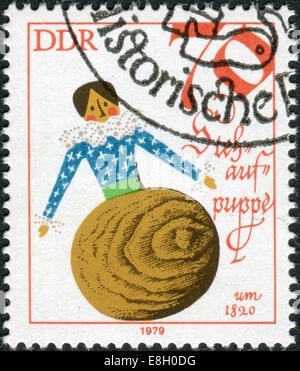 GERMANY - CIRCA 1979: Postage stamp printed in Germany (GDR), shows a vintage doll - Tumbler, 1820, circa 1979 Stock Photo