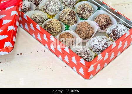 Homemade chocolate truffles with different coatings such as coconut, crushed almonds or hazelnuts or walnuts. Each placed in a d Stock Photo