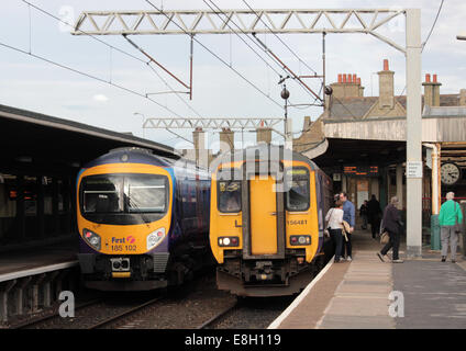 Two passenger trains in Carnforth station, a First Trans Pennine Express class 185 unit and a Northern Rail class 156 unit. Stock Photo