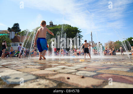 Families enjoying the water spout fountains near the harbour at Folkestone. Stock Photo