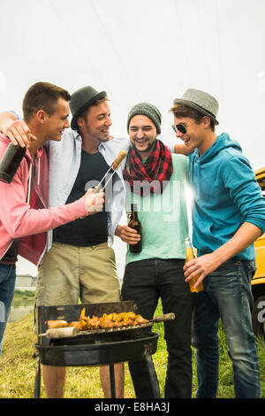 Group of friends drinking beer and having a barbecue Stock Photo - Alamy