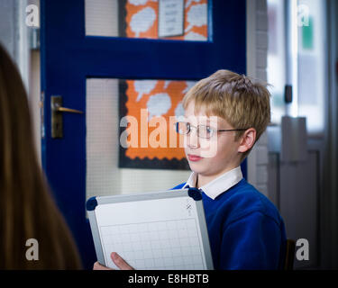 Boy in glasses with mini white board in UK Primary School classroom Stock Photo