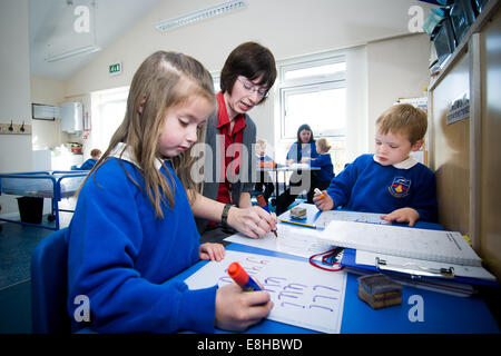 Children in pre-school class of primary school in UK with early years teacher practicing literacy. Stock Photo