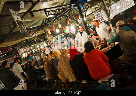 Horizontal view of the busy temporary food stalls set up in Place Jemaa el Fna (Djemaa el Fnaa) in Marrakech at night. Stock Photo
