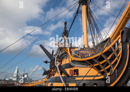 Bow, anchor, hull and mast of HMS Victory without the masts and rigging during its major re-fit, with HMS Dauntless D33, a Type Stock Photo