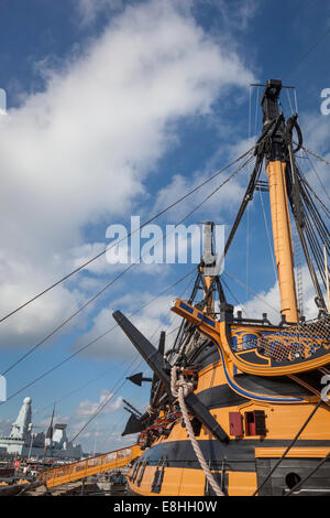 Bow, anchor, hull and mast of HMS Victory without the masts and rigging during its major re-fit, with HMS Dauntless D33 behind. Stock Photo