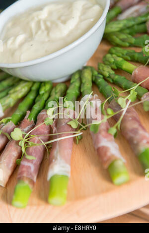 Asparagus wrapped in ham with dip, Savoury Canapes on a tray. Stock Photo