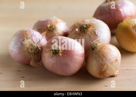 group of pink toned figuera Spanish onions on light wood table, Stock Photo