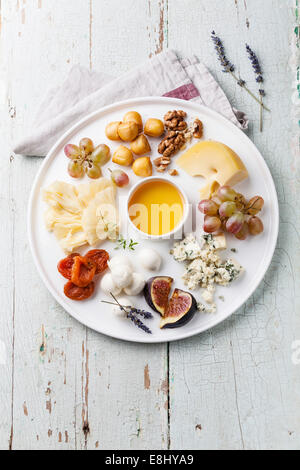 Cheese plate Assortment of various types of cheese and honey on white plate Stock Photo