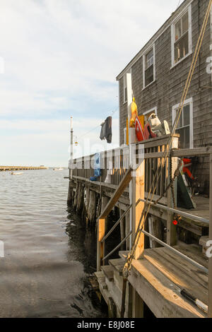 A shingled building on pilings on the water in Provincetown, Massachusetts Stock Photo