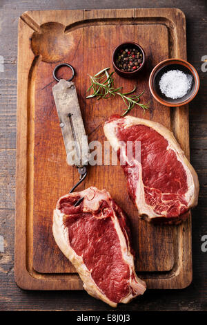 Raw fresh meat Ribeye Steak, seasoning and vintage steelyard on dark background Stock Photo