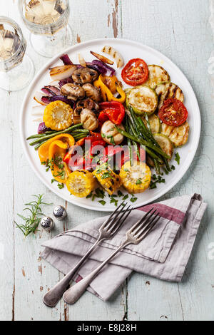 Grilled vegetables on the white plate on blue textured background Stock Photo