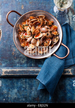 Shells vongole with parsley and tomato sauce and wine on blue background Stock Photo