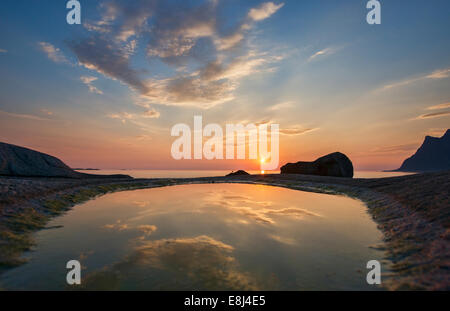 the midnight sun over the Arctic from Uttakleiv Beach in the Lofoten Islands, Norway Stock Photo