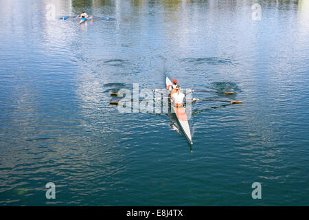 Two Women Rower in a boat, rowing on the tranquil lake Stock Photo