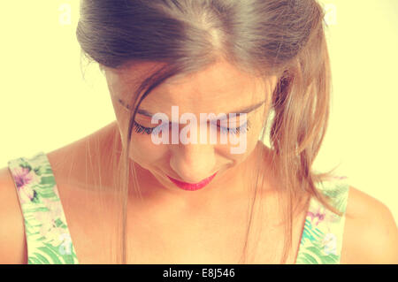 portrait of a young brunette woman looking downwards, with a retro effect Stock Photo