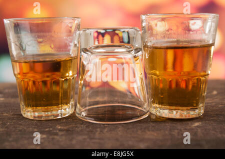 glass of rum whiskey over defocused lights background Stock Photo
