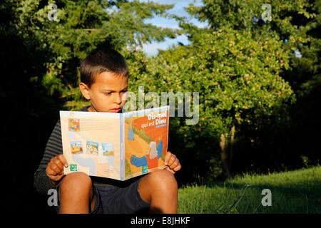7-year-old boy reading a Christian book for children Stock Photo