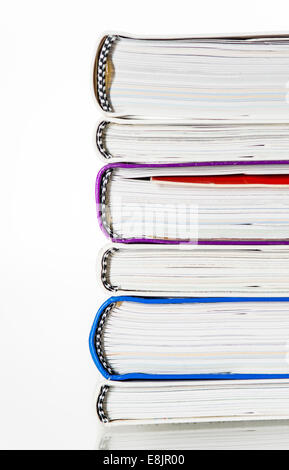side-on view of a stack of books, portrait photograph, white background, lines of colour, mainly white with strips of colour Stock Photo