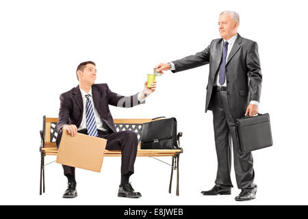 Mature businessman giving some money to a beggar isolated on white background Stock Photo