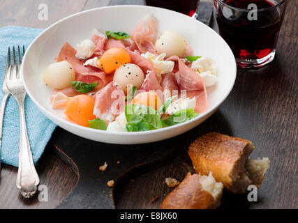 Melon and prosciutto ham salad with Mozzarella Stock Photo