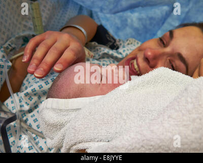 Mother and baby meeting for the first time in Cesarean operating theatre, just after cesarean operation. Stock Photo
