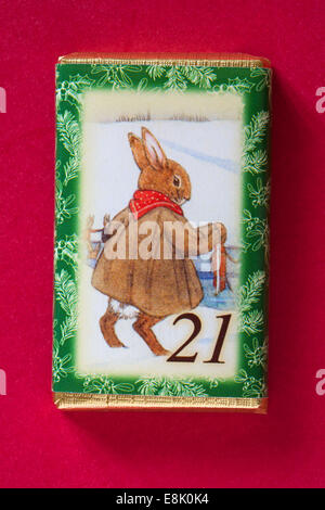 Count down to Christmas with individual advent chocolate bars isolated on red background - calendar day 21 of set of 24 Stock Photo