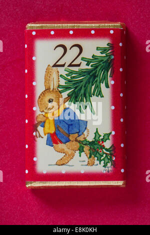 Count down to Christmas with individual advent chocolate bars isolated on red background - calendar day 22 of set of 24 Stock Photo