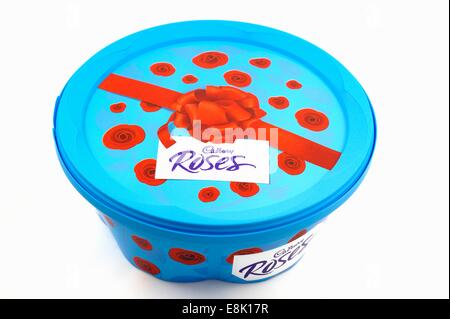 A plastic tub of roses assorted chocolates on a white studio background Stock Photo