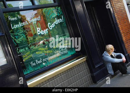 young man sitting outside London pub Stock Photo