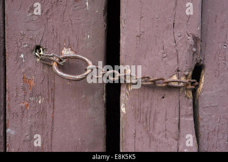 Rusty chain on an old barn door Stock Photo
