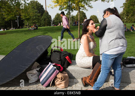 Asian model has her make up done my a make up artist prior to a photo shoot at Jubilee Gardens. The South Bank, London, UK. Stock Photo