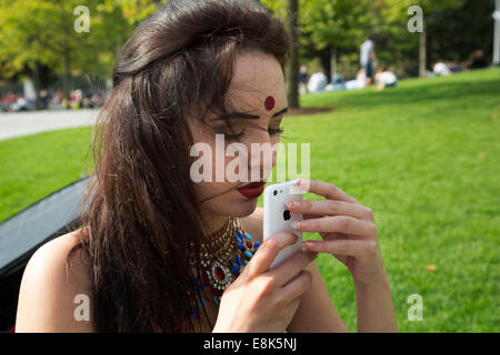 Asian model has her make up done my a make up artist prior to a photo shoot at Jubilee Gardens. The South Bank, London, UK. Stock Photo