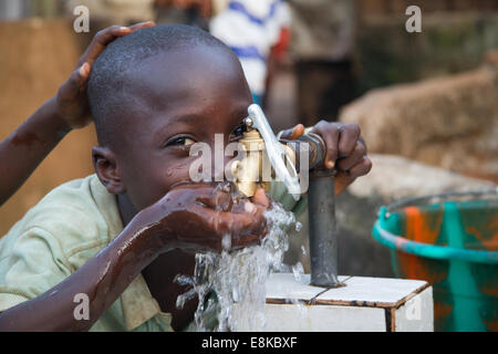 Boy drinking water from faucet, Kroo Bay, Freetown, Sierra Leone. Photo © Nile Sprague Stock Photo