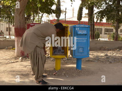 Quetta. 9th Oct, 2014. A Pakistani postman collects mails from a mailbox on the World Post Day in southwest Pakistan's Quetta on Oct. 9, 2014. World Post Day is celebrated each year on Oct. 9, the anniversary of the establishment of the Universal Postal Union (UPU) in 1874 in Berne, the Swiss capital. © Asad/Xinhua/Alamy Live News Stock Photo