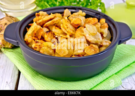 Jerusalem artichokes roasted in a roasting pan, fresh tubers on a napkin, parsley, vegetable oil on a background of white wooden Stock Photo