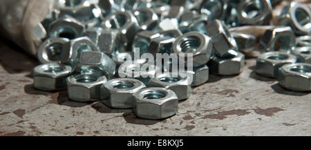 Plastic bag of load of new alloy nuts over a mechanic table Stock Photo