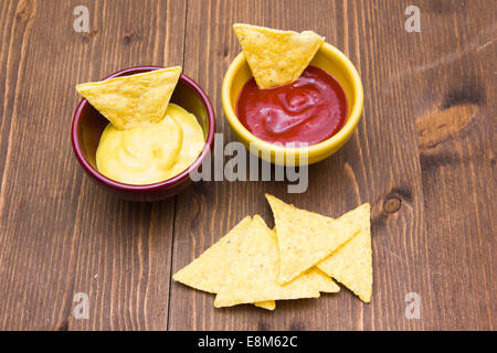 Nachos on wooden table with sauces Stock Photo