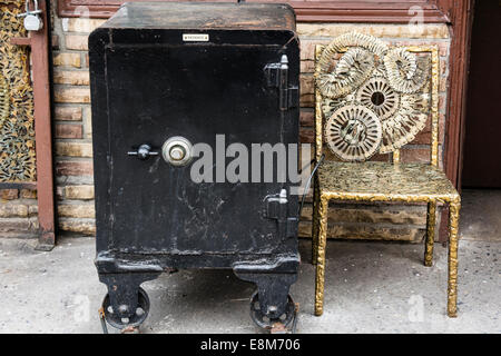 Old black, metal safe with combination lock and sculpture chair made with keys by Phil Mortillaro at his Locksmith shop in Greenwich Village, New York Stock Photo
